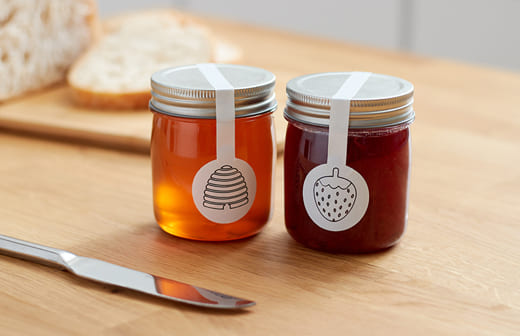 Barattoli con etichette contenenti miele e marmellata