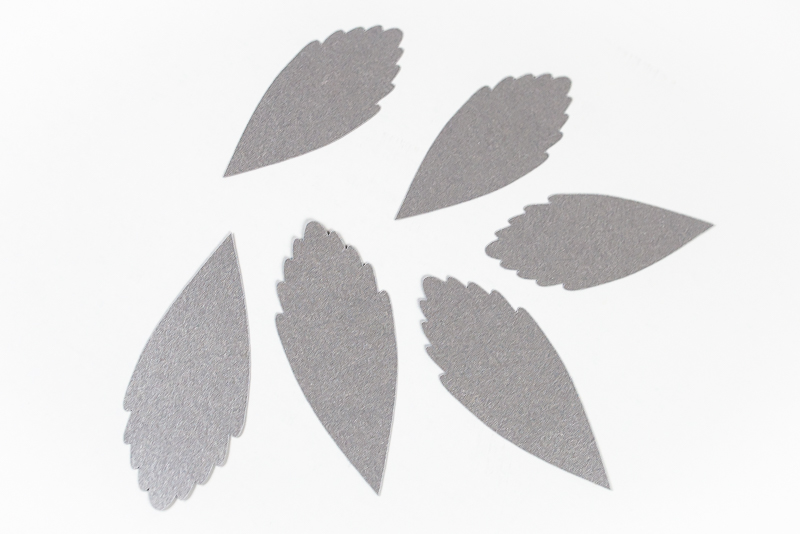 Images of several layers of a silver-colored paper leaves